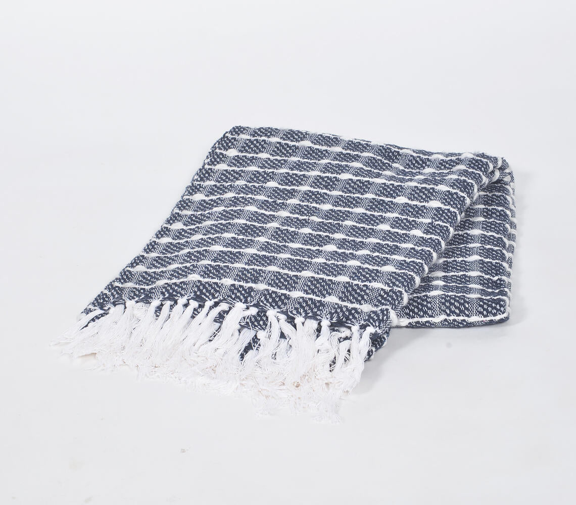 Cozy up on the couch with the Handwoven Cotton Throw from Pembroke Lane. The textured check pattern and soft cotton provide warmth and style for any living space.